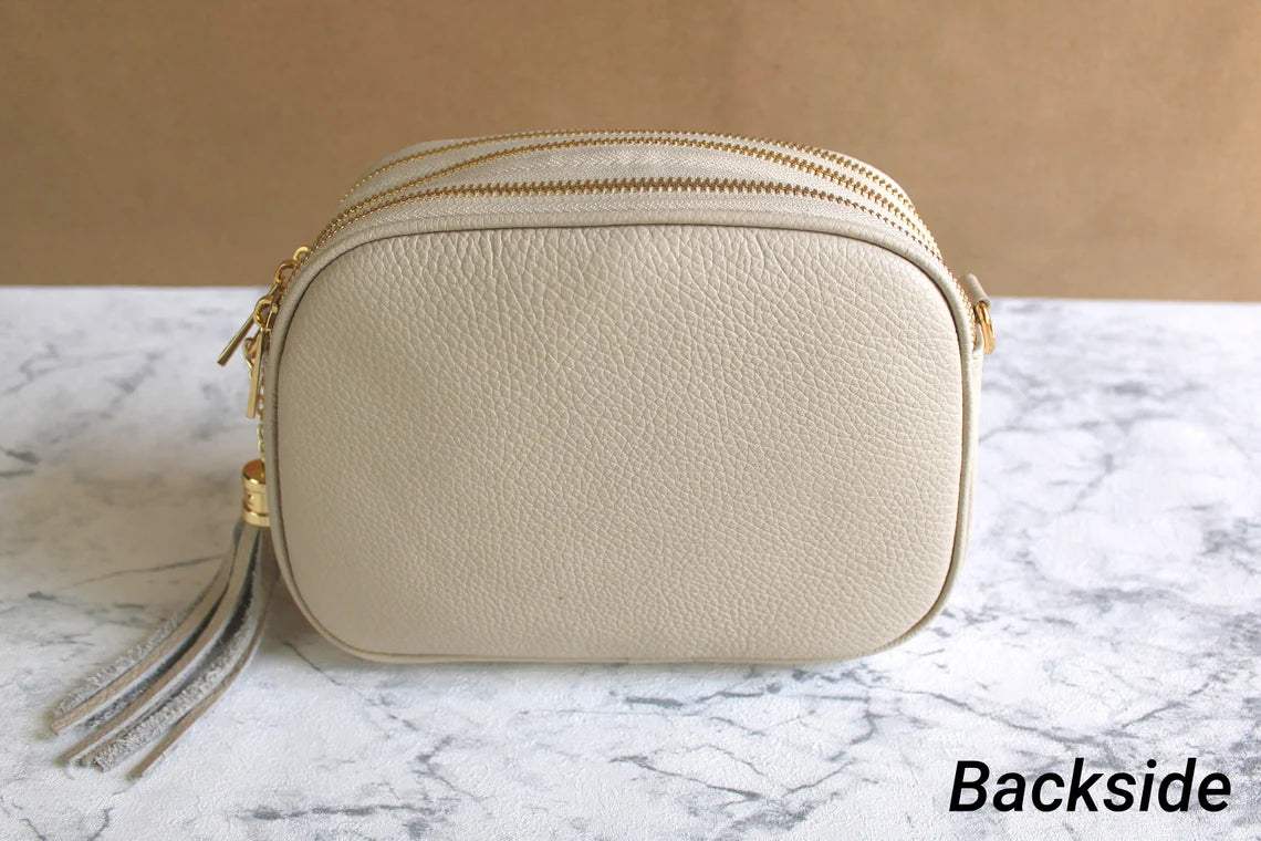 Beigefarbene Tasche mit goldenem Lederarmband